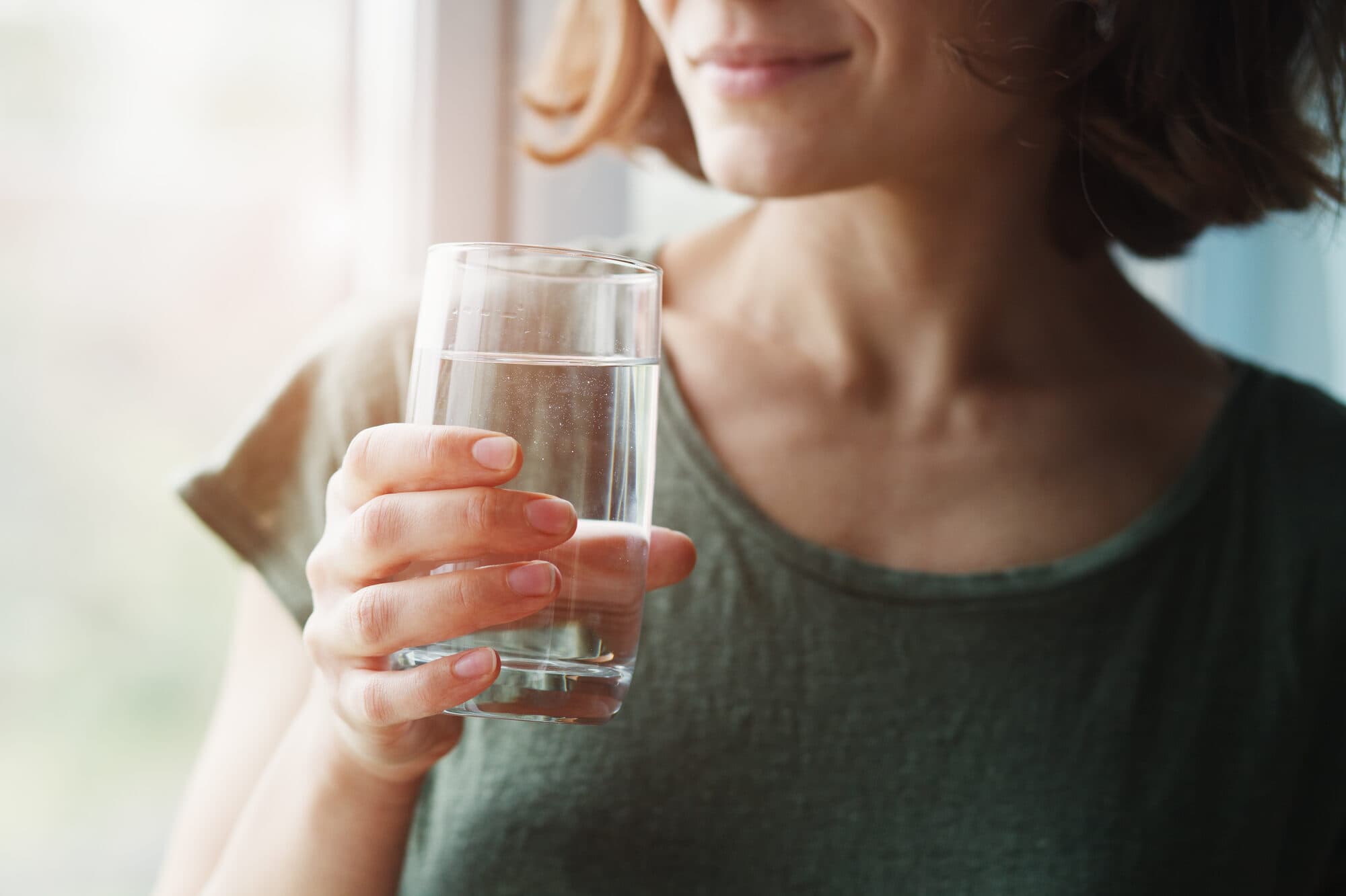 Homeowner holding a glass of clear filtered water