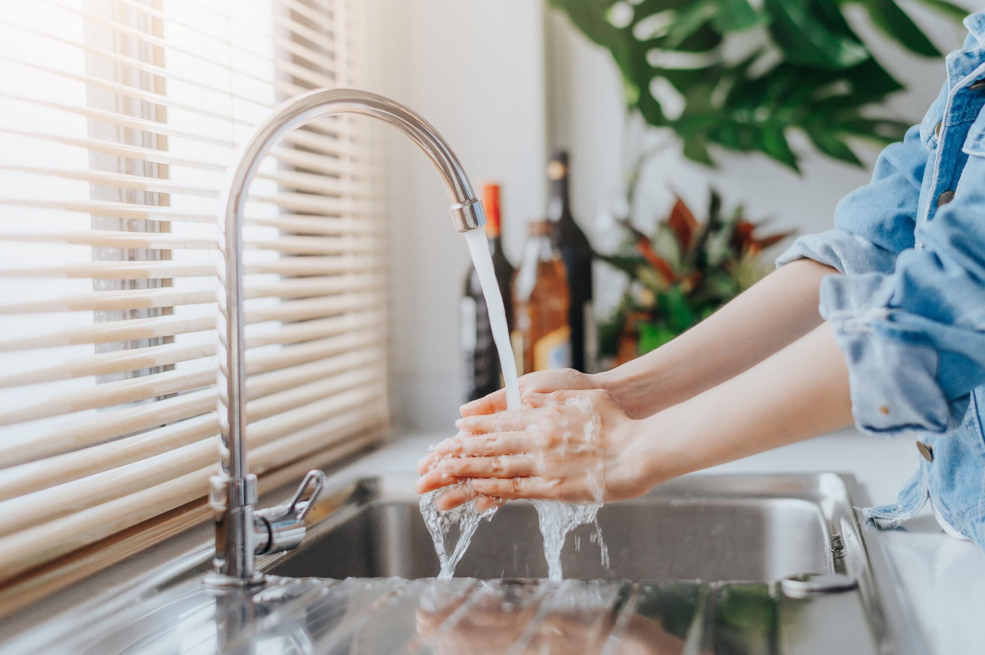 Washing hands under a kitchen tap with filtered water